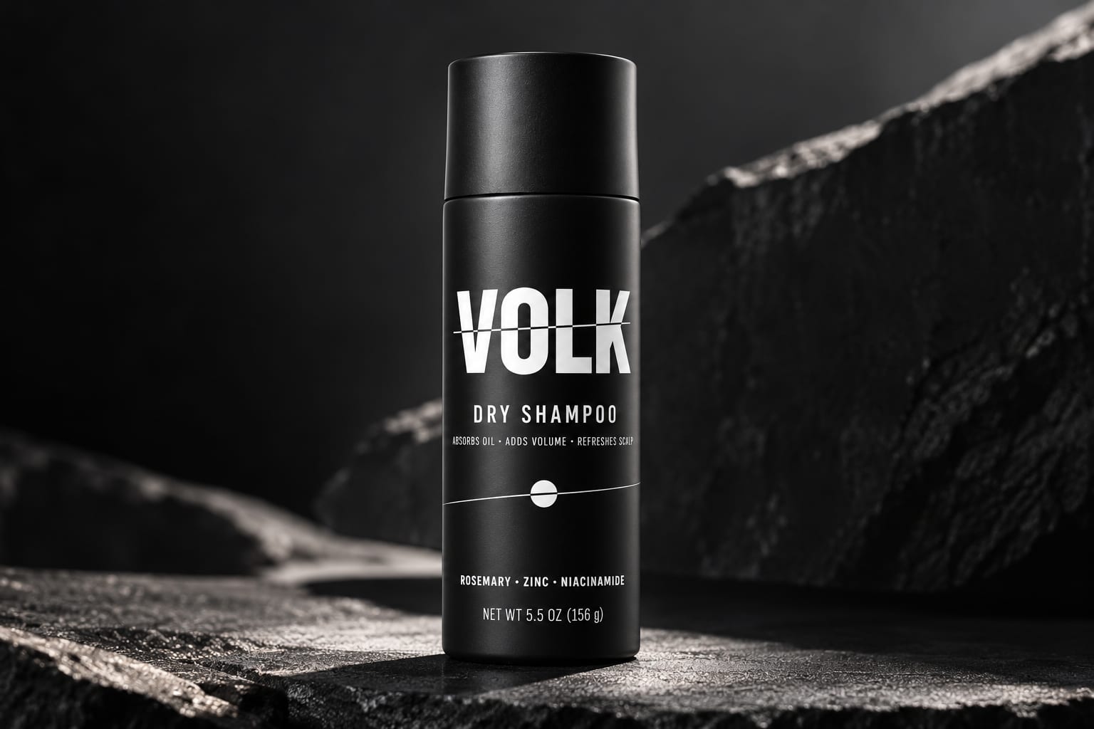 VOLK Dry Shampoo aerosol can standing on a dark stone ledge